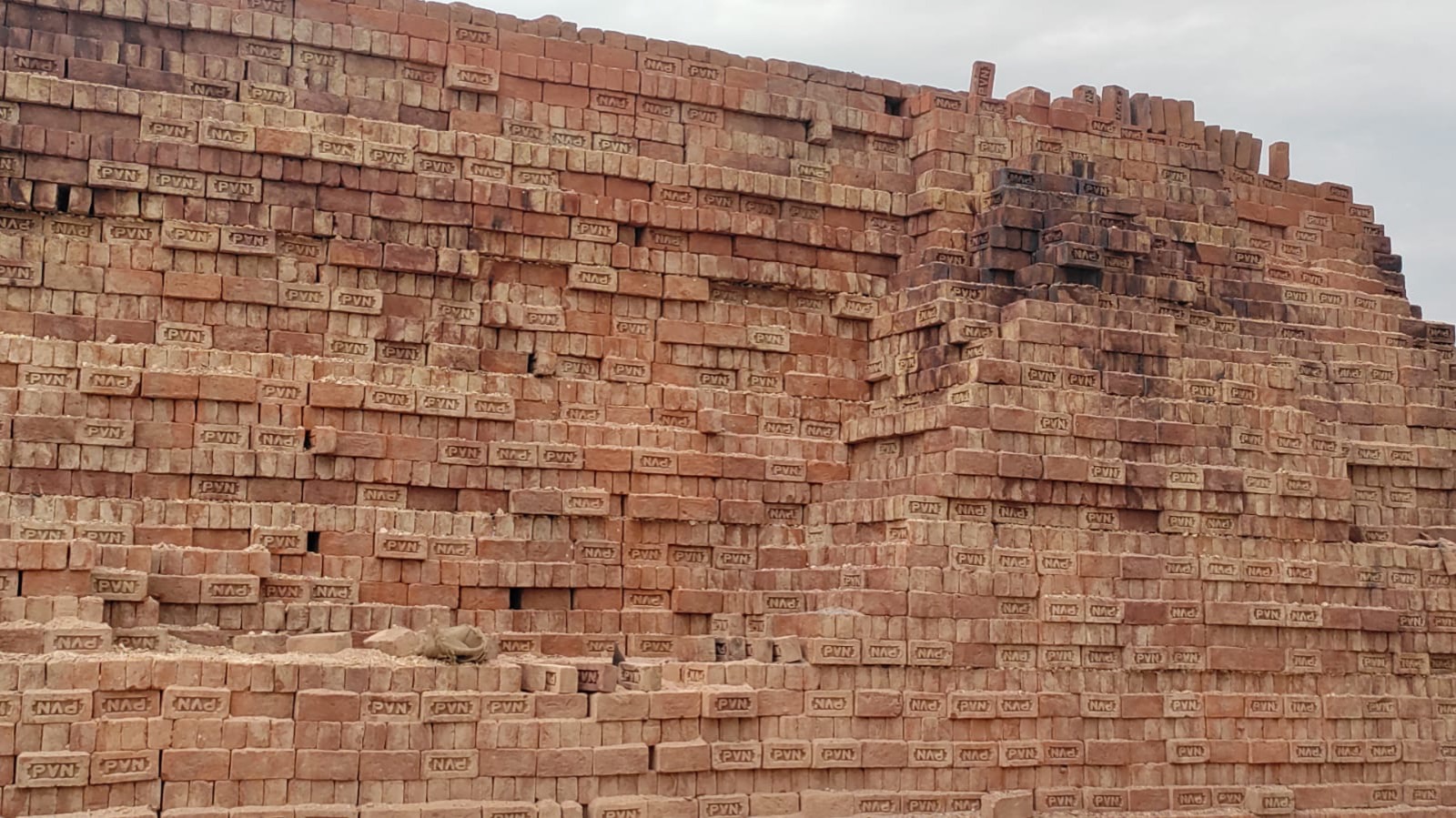 Thousands of red PVN bricks stacked high in the stock yard